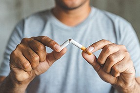 Closeup of patient breaking cigarette 