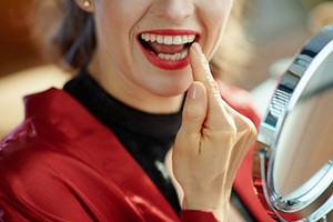 a patient admiring her smile in a mirror