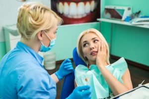 Woman in pain at emergency dentist.