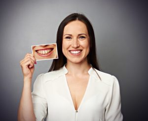 Smiling woman holds photo pf before visiting her North Dallas cosmetic dentist