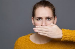 Young woman covering her mouth with hand