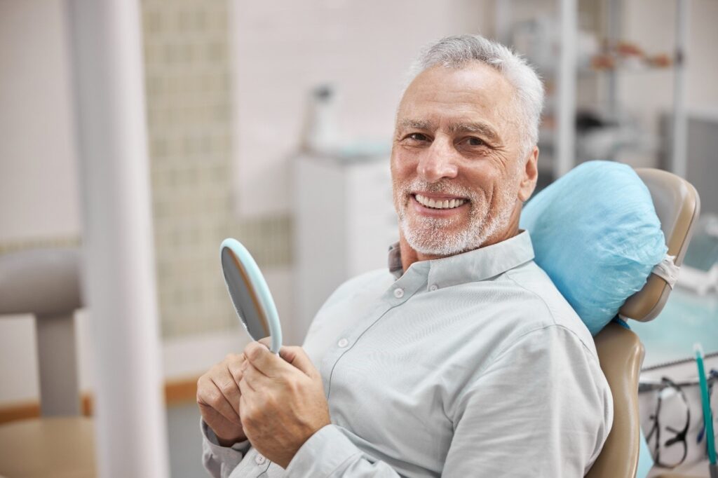 person smiling after receiving dental implants