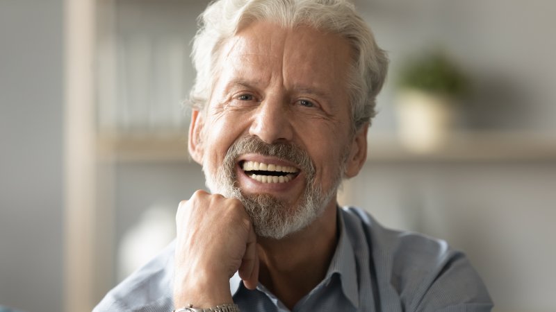 An older man smiling after receiving dental care